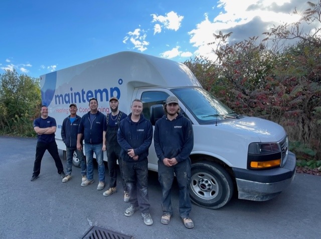 Five people are standing beside a white van with the logo "maintempo" on it, which suggests they are a team, possibly a maintenance crew.
